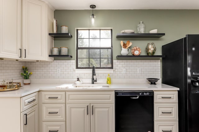 kitchen with decorative backsplash, sink, hanging light fixtures, and black appliances