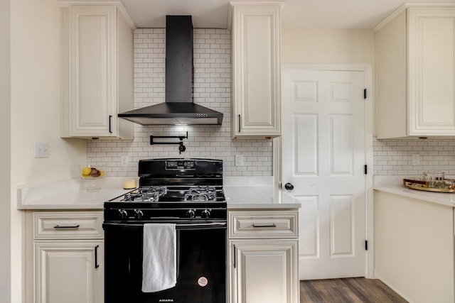 kitchen with tasteful backsplash, black gas range oven, dark hardwood / wood-style floors, and wall chimney exhaust hood