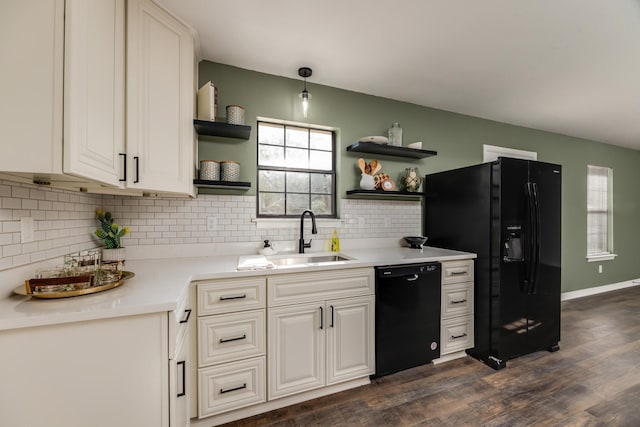 kitchen with sink, dark wood-type flooring, hanging light fixtures, black appliances, and decorative backsplash