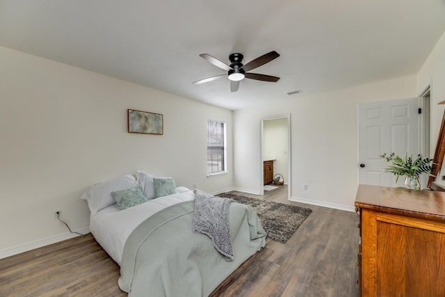 bedroom featuring ensuite bathroom, dark hardwood / wood-style floors, and ceiling fan