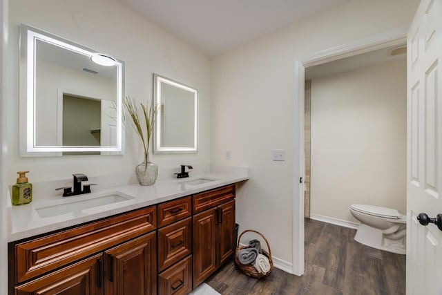 bathroom with wood-type flooring, toilet, and vanity