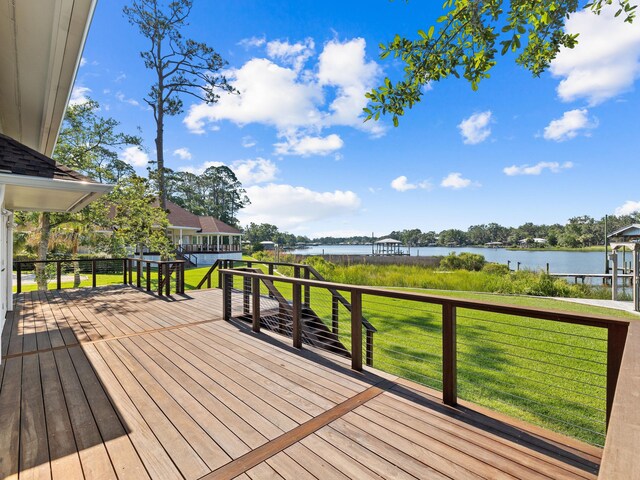 deck with a water view and a yard