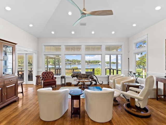 living room featuring ceiling fan, french doors, a towering ceiling, and hardwood / wood-style flooring