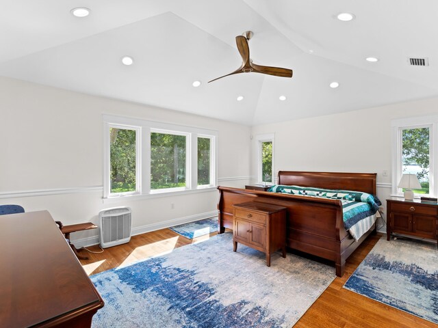 bedroom with vaulted ceiling, wood-type flooring, ceiling fan, and multiple windows