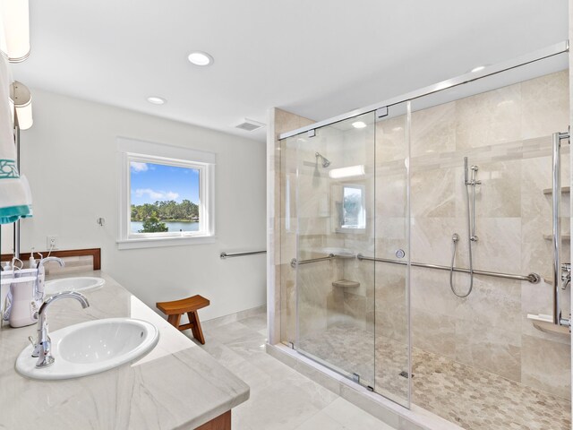 bathroom with double vanity, an enclosed shower, and tile flooring