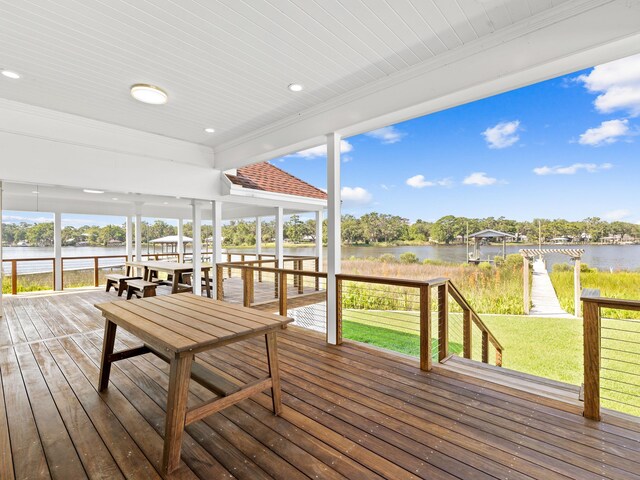 wooden deck with a lawn, a boat dock, and a water view