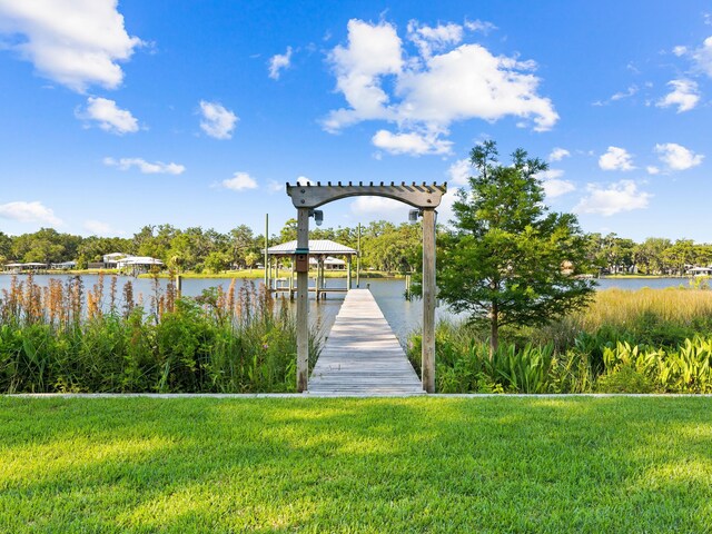 view of dock with a water view and a yard