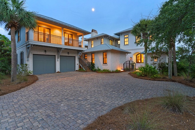 view of front of house with stucco siding, a chimney, decorative driveway, and a garage