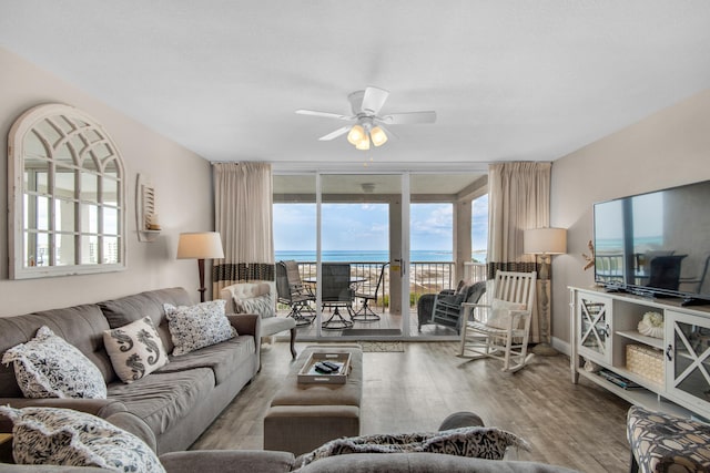 living room with ceiling fan, expansive windows, and hardwood / wood-style floors