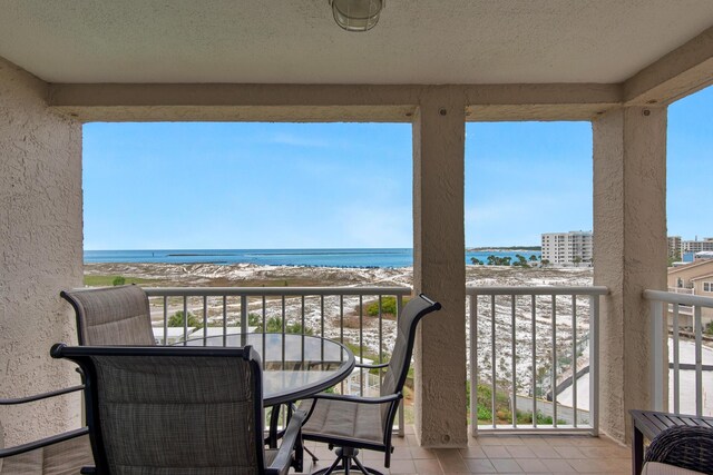 balcony with a water view and a beach view