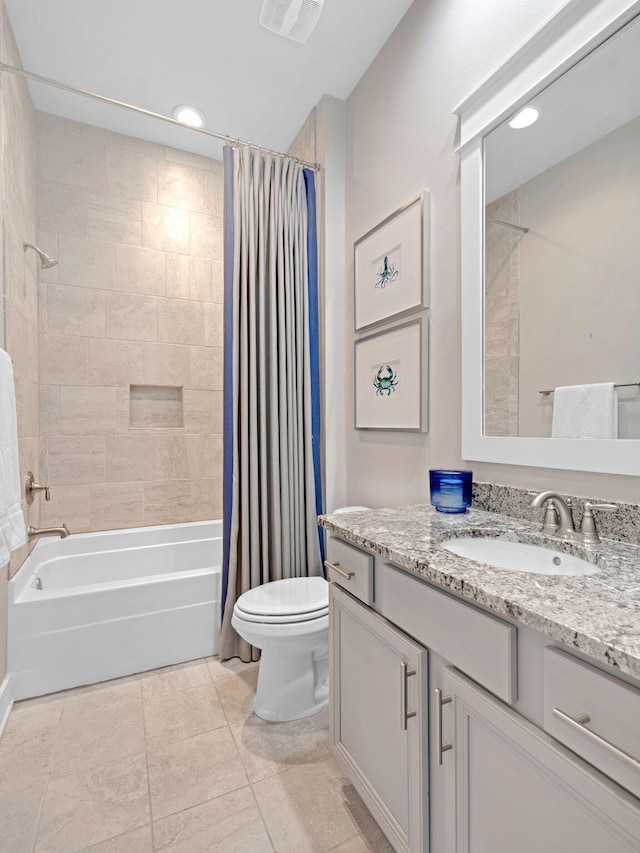 full bathroom featuring toilet, tile patterned floors, vanity, and shower / tub combo with curtain