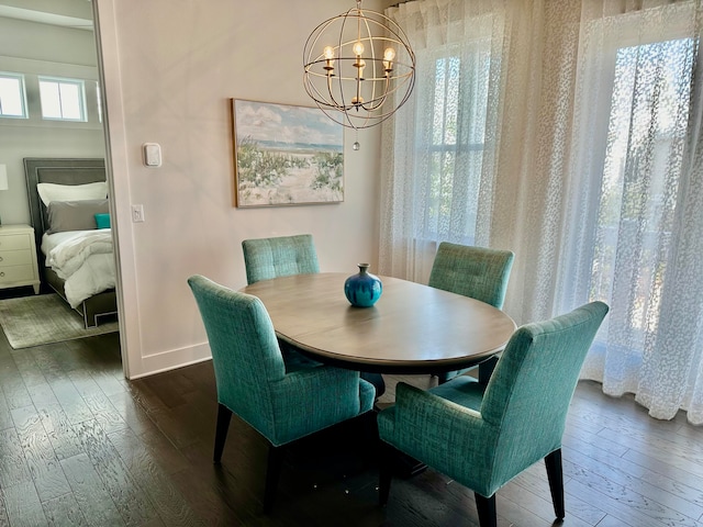 dining space with dark hardwood / wood-style flooring and a chandelier