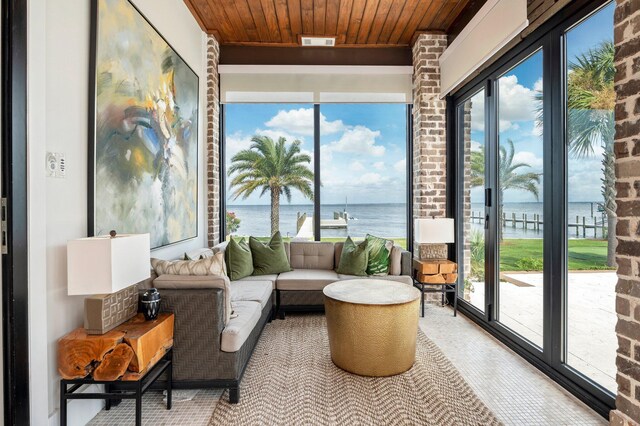 sunroom with a water view, a wealth of natural light, and wood ceiling