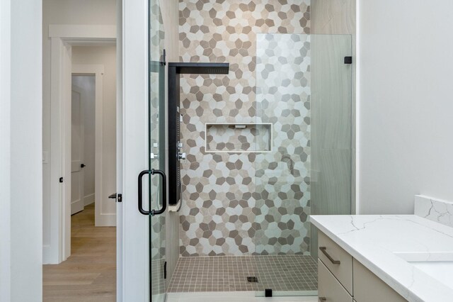 bathroom featuring wood-type flooring, vanity, and walk in shower