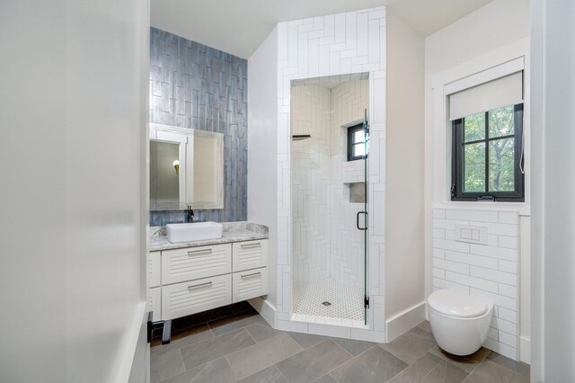 bathroom featuring vanity, toilet, tile walls, and walk in shower