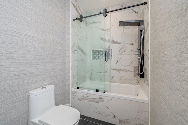 bathroom featuring tile patterned floors, toilet, and combined bath / shower with glass door