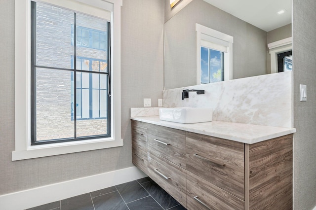 bathroom with a wealth of natural light, tile patterned flooring, and vanity