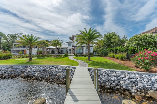 view of dock with a yard and a water view