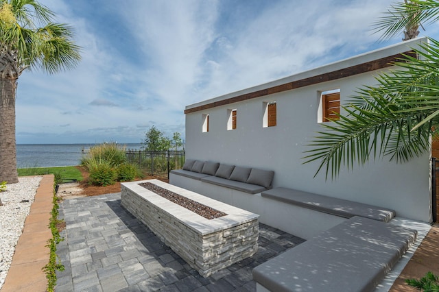 view of patio / terrace with a water view and an outdoor fire pit