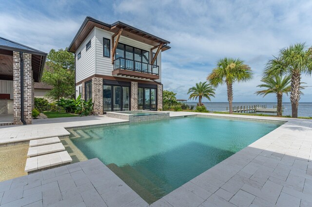 view of pool with a water view, an in ground hot tub, and a patio