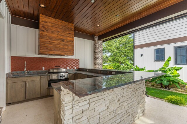 view of patio featuring area for grilling, an outdoor wet bar, and exterior kitchen