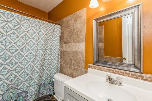 bathroom featuring tile walls, a textured ceiling, vanity, and toilet