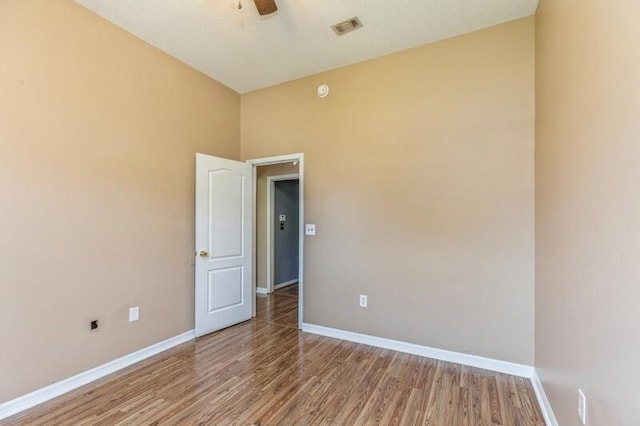 spare room with a towering ceiling and hardwood / wood-style flooring