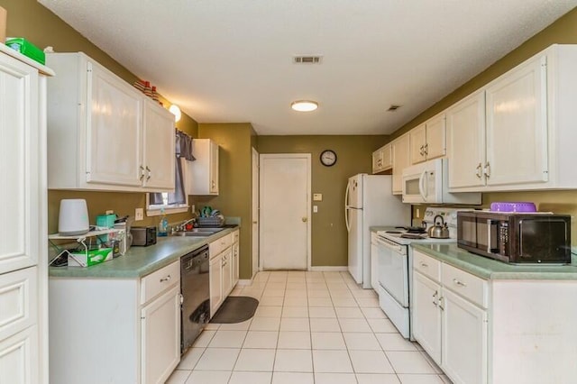 kitchen with sink, white cabinets, light tile flooring, and black appliances