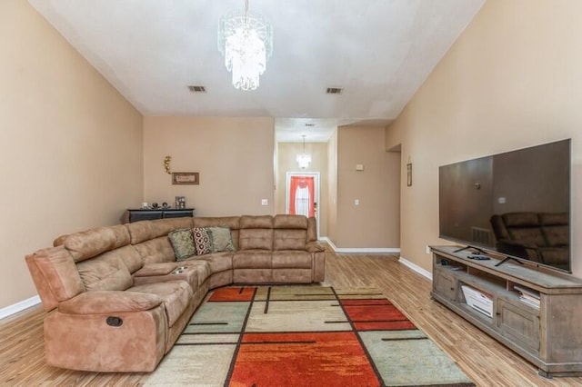 living room with an inviting chandelier and light hardwood / wood-style flooring