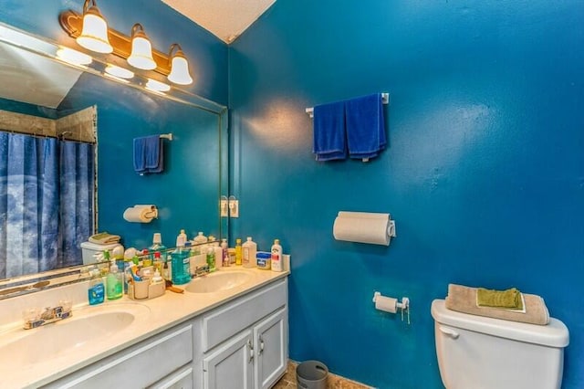 bathroom with dual bowl vanity and toilet