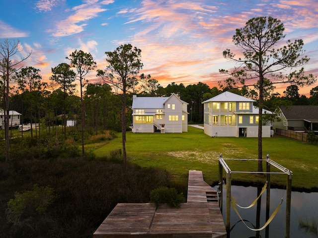 dock area featuring a lawn, a balcony, and fence