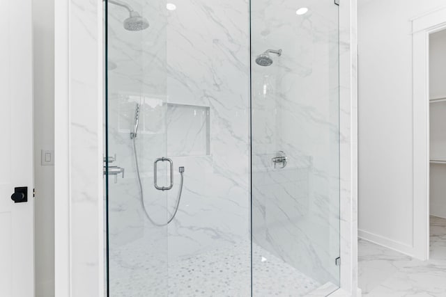 full bath with marble finish floor, a marble finish shower, and baseboards