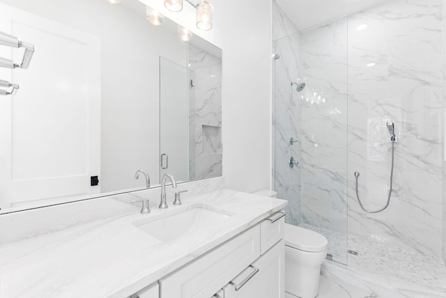 bathroom featuring toilet, marble finish floor, a marble finish shower, and vanity