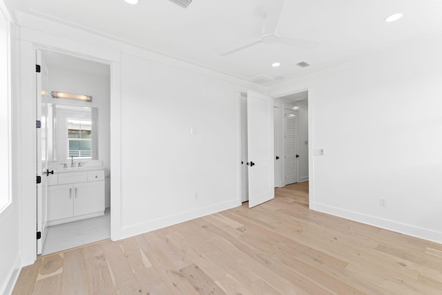 spare room featuring light wood-type flooring, baseboards, ornamental molding, and ceiling fan