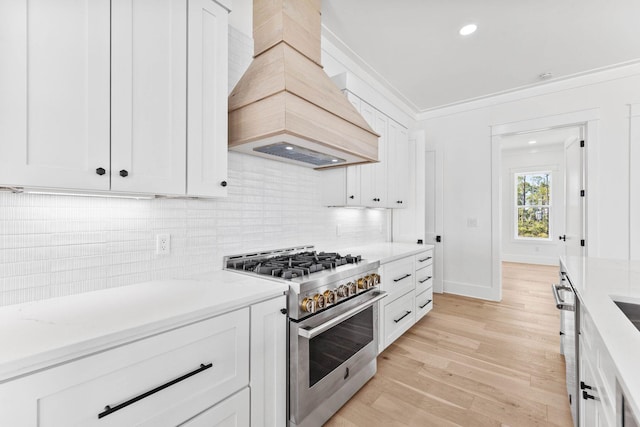 109 W Nursery Rd, Santa Rosa Beach, FL 32459 - kitchen with high end stainless steel range, backsplash, light wood-style floors, custom range hood, and white cabinetry