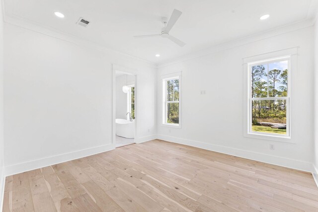 empty room with a healthy amount of sunlight, crown molding, ceiling fan, and light hardwood / wood-style floors