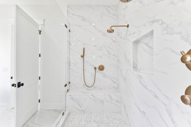 bathroom with a tile shower and tile patterned floors