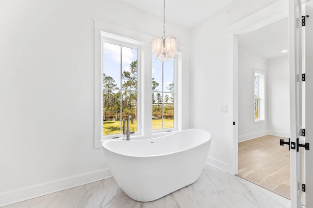 109 W Nursery Rd, Santa Rosa Beach, FL 32459 - bathroom with a chandelier, baseboards, a freestanding tub, and marble finish floors