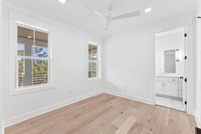 empty room featuring light hardwood / wood-style flooring, a healthy amount of sunlight, ceiling fan, and crown molding