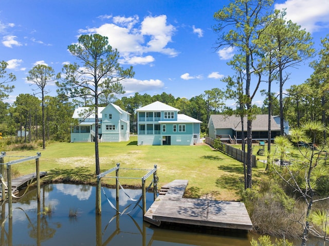 view of dock with a water view and a lawn