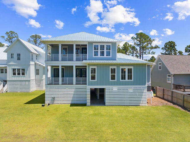 back of house featuring a balcony and a lawn