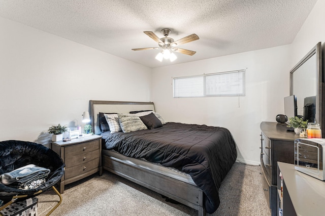 bedroom with ceiling fan, a textured ceiling, and light carpet