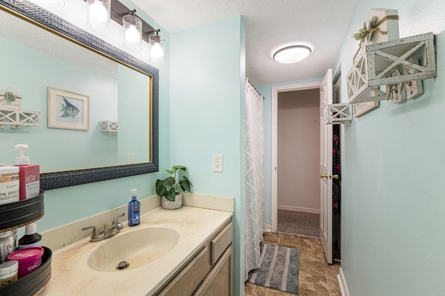 bathroom featuring a textured ceiling, tile flooring, and vanity