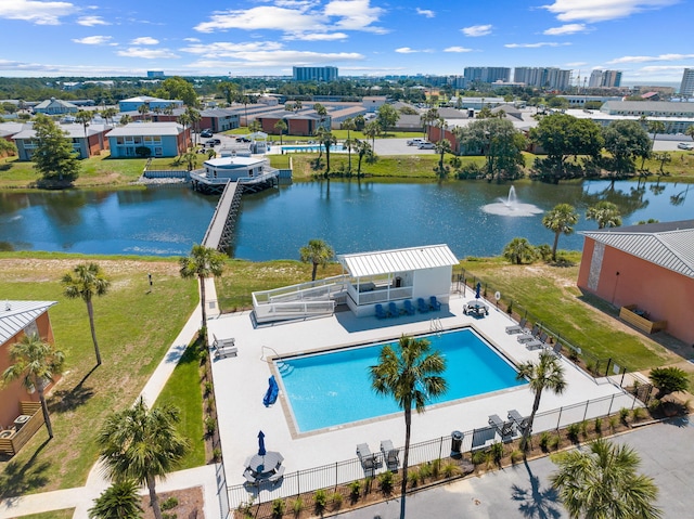 view of swimming pool featuring a water view, a lawn, and a patio area