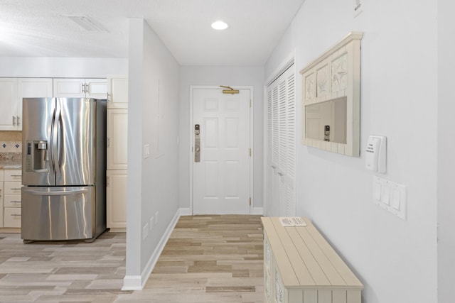 interior space with a textured ceiling and light wood-type flooring