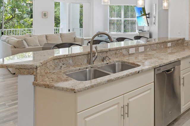 kitchen with dishwasher, pendant lighting, white cabinetry, and sink