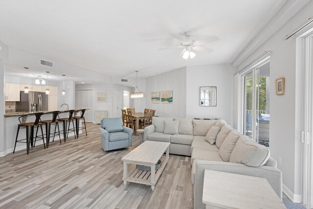 living room with ceiling fan and light hardwood / wood-style flooring