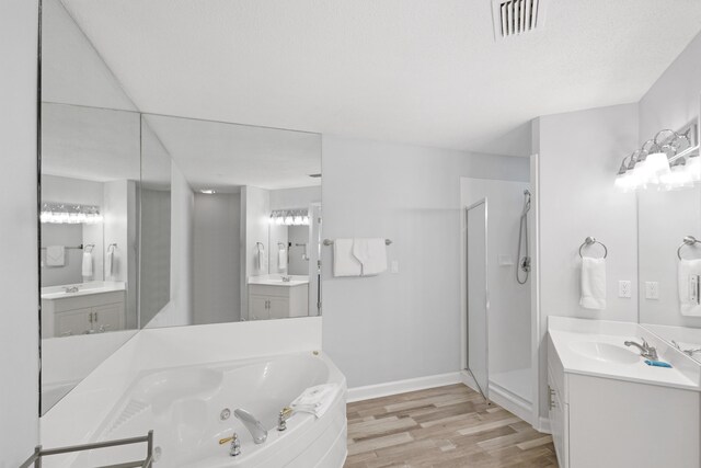 bathroom with vanity, wood-type flooring, and plus walk in shower