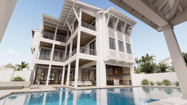 rear view of house featuring a balcony, a patio, and a fenced in pool