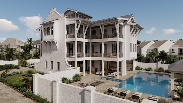 rear view of house with a patio, a balcony, and a fenced in pool